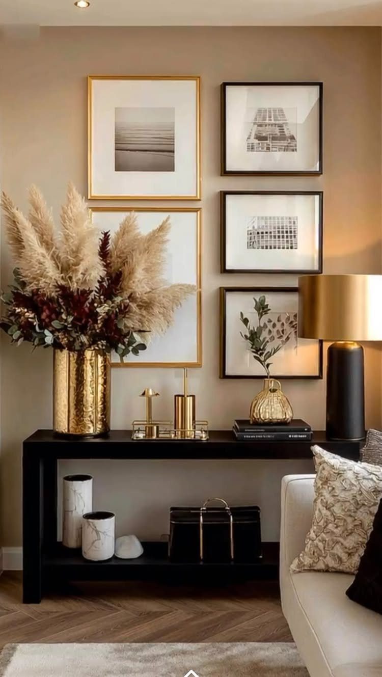 Framed black and white art pieces arranged on a beige wall above a black console table.