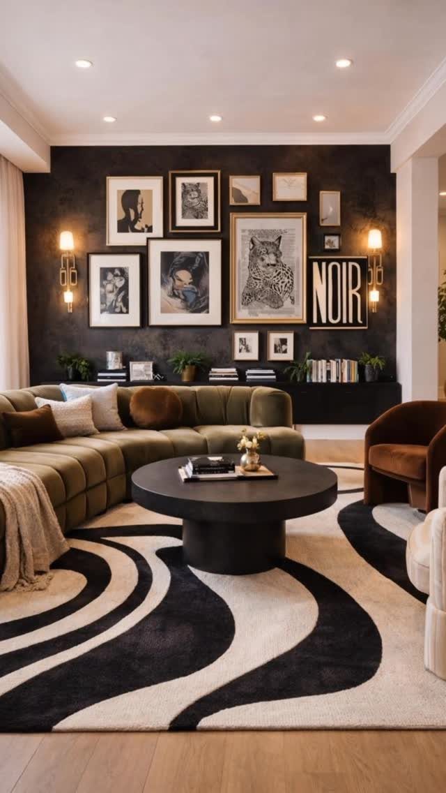 A collection of framed black and white art pieces arranged on a dark accent wall above a sofa.