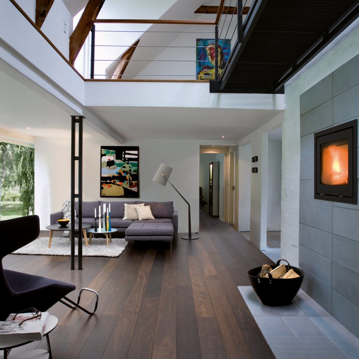 Dark wood plank flooring in a modern living room with a grey sofa and fireplace.