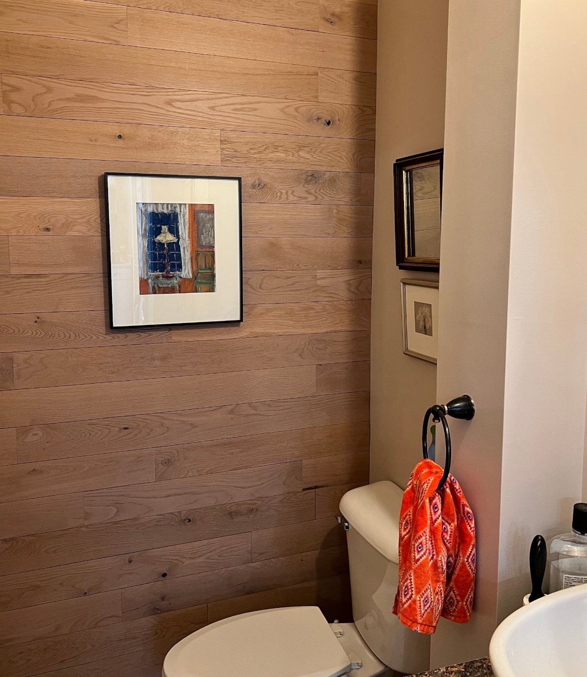 9 Natural Wood Shiplap Wall Ideas for Every Room 1 Horizontal natural wood planks covering a bathroom wall with a small framed picture hanging on it.