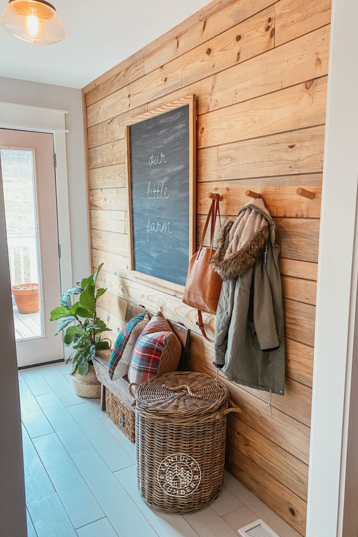 9 Natural Wood Shiplap Wall Ideas for Every Room 7 Horizontal natural wood shiplap planks covering a mudroom wall with hooks, a chalkboard, and a bench.