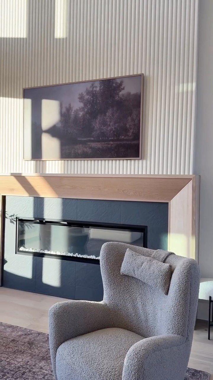 Vertical cream fluted wall panels above a modern fireplace and wooden mantelpiece.