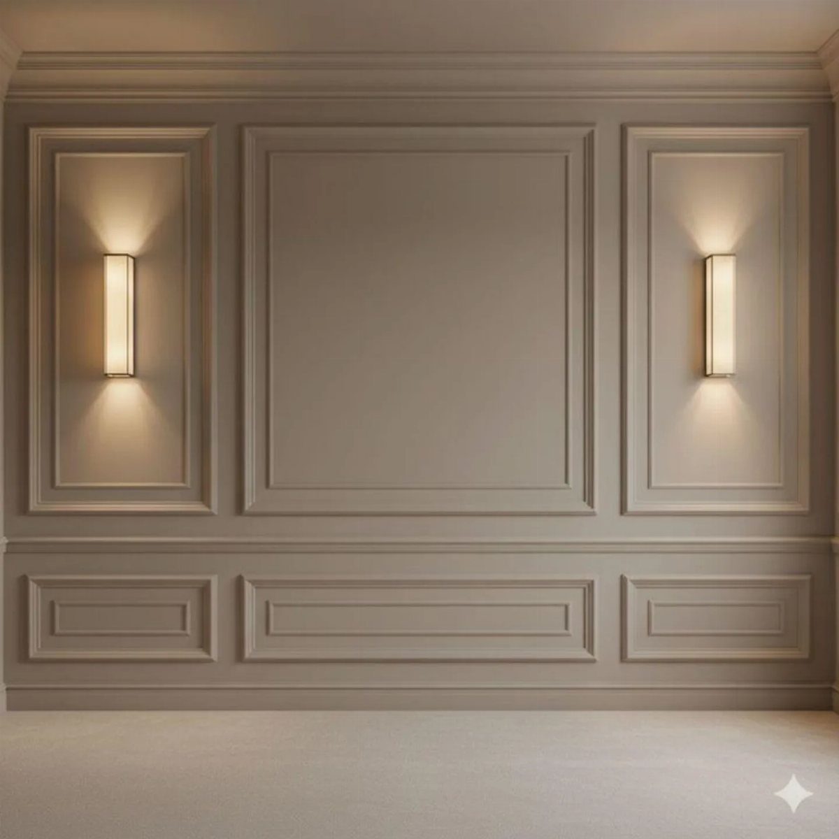 Beige wall with decorative picture frame molding and two glowing vertical wall sconces.