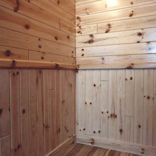 Light pine wood paneling with horizontal planks on top and vertical planks on the bottom.