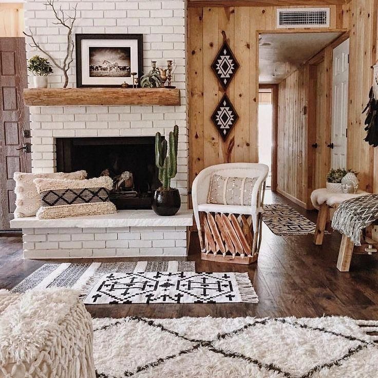 Knotty pine wood paneled walls in a rustic living room with a white brick fireplace.