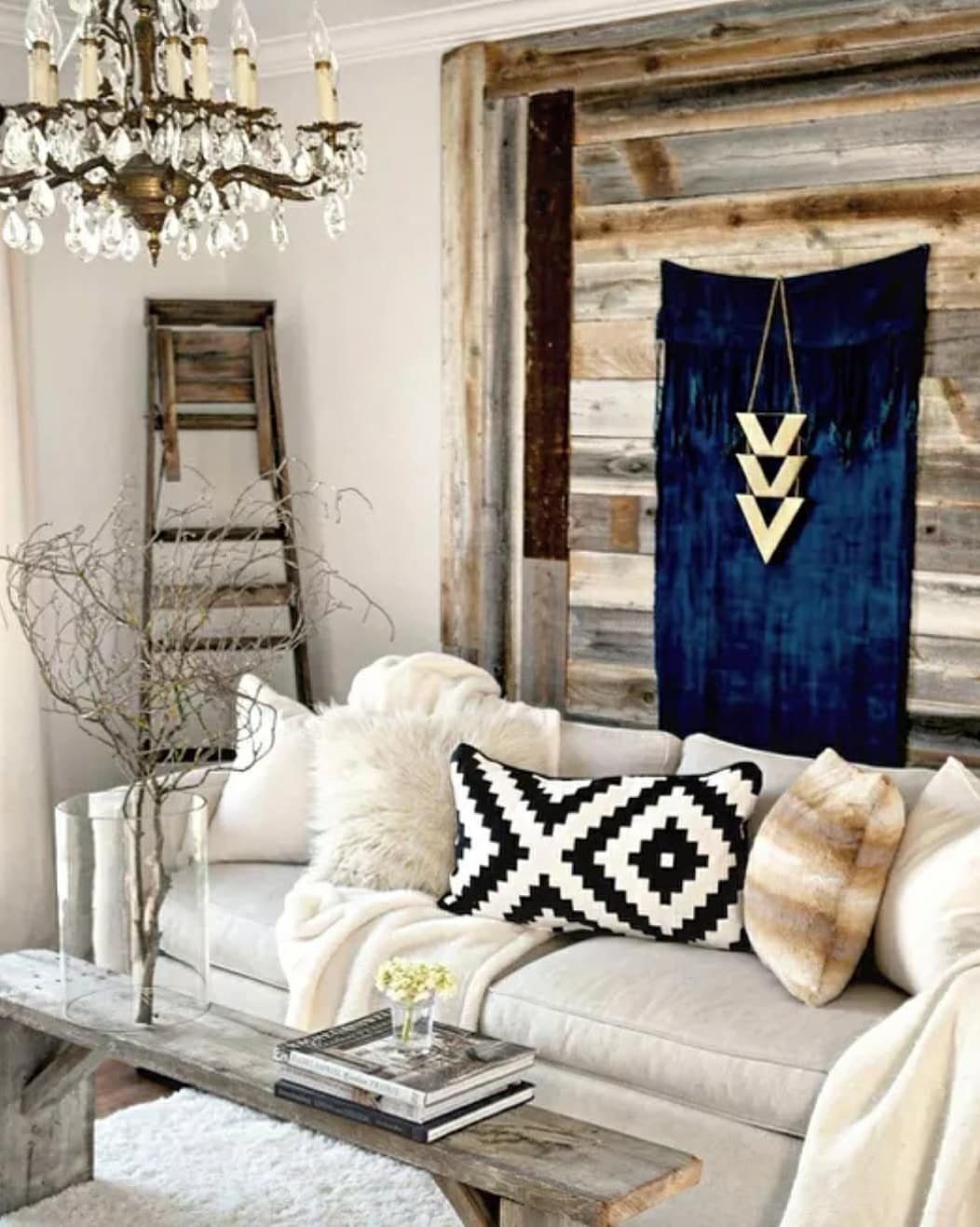 A rustic living room with a white sofa and a weathered wood plank accent wall.