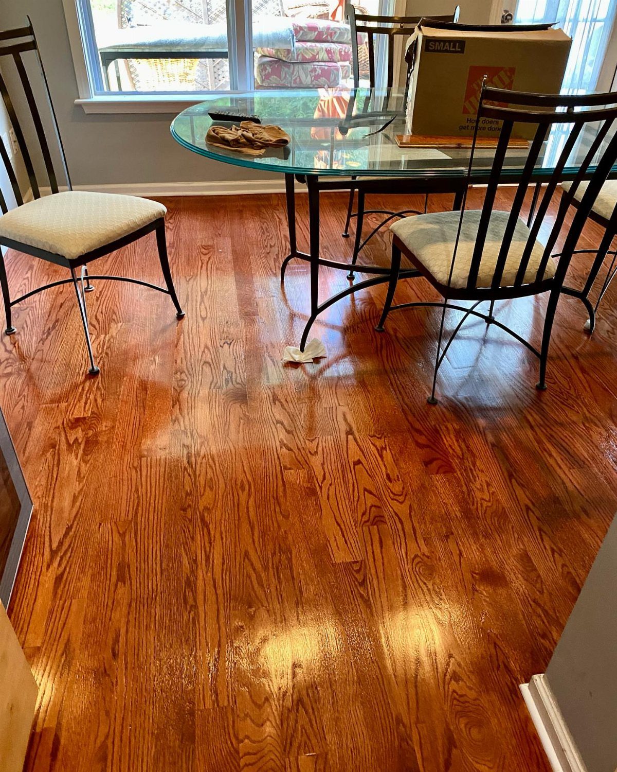 Reddish-brown hardwood floors with a glossy finish in a dining room setting.
