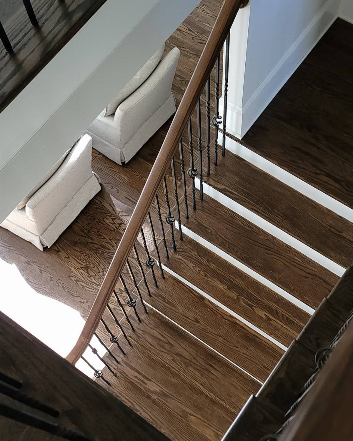 Dark brown wooden stairs with white risers and a matching wood floor in a hallway.