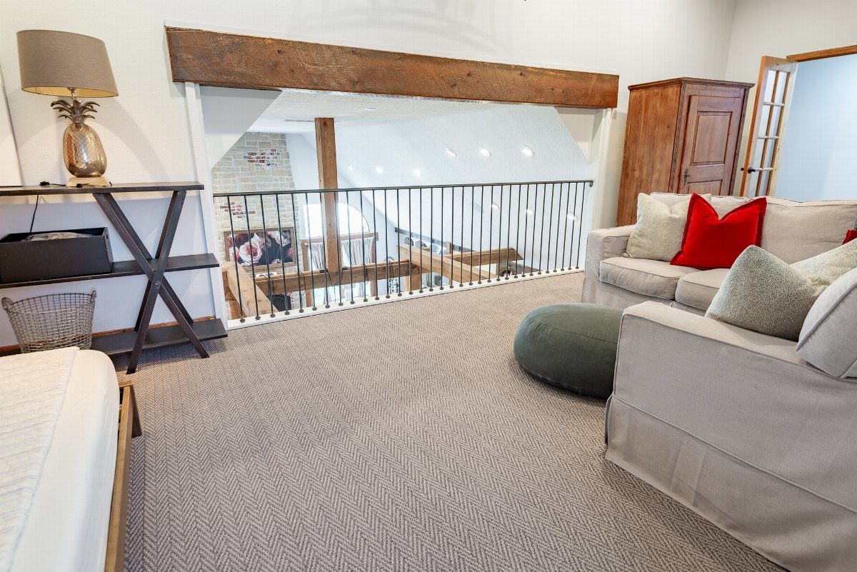 Grey textured carpet covering the floor of a modern living room area near a staircase.