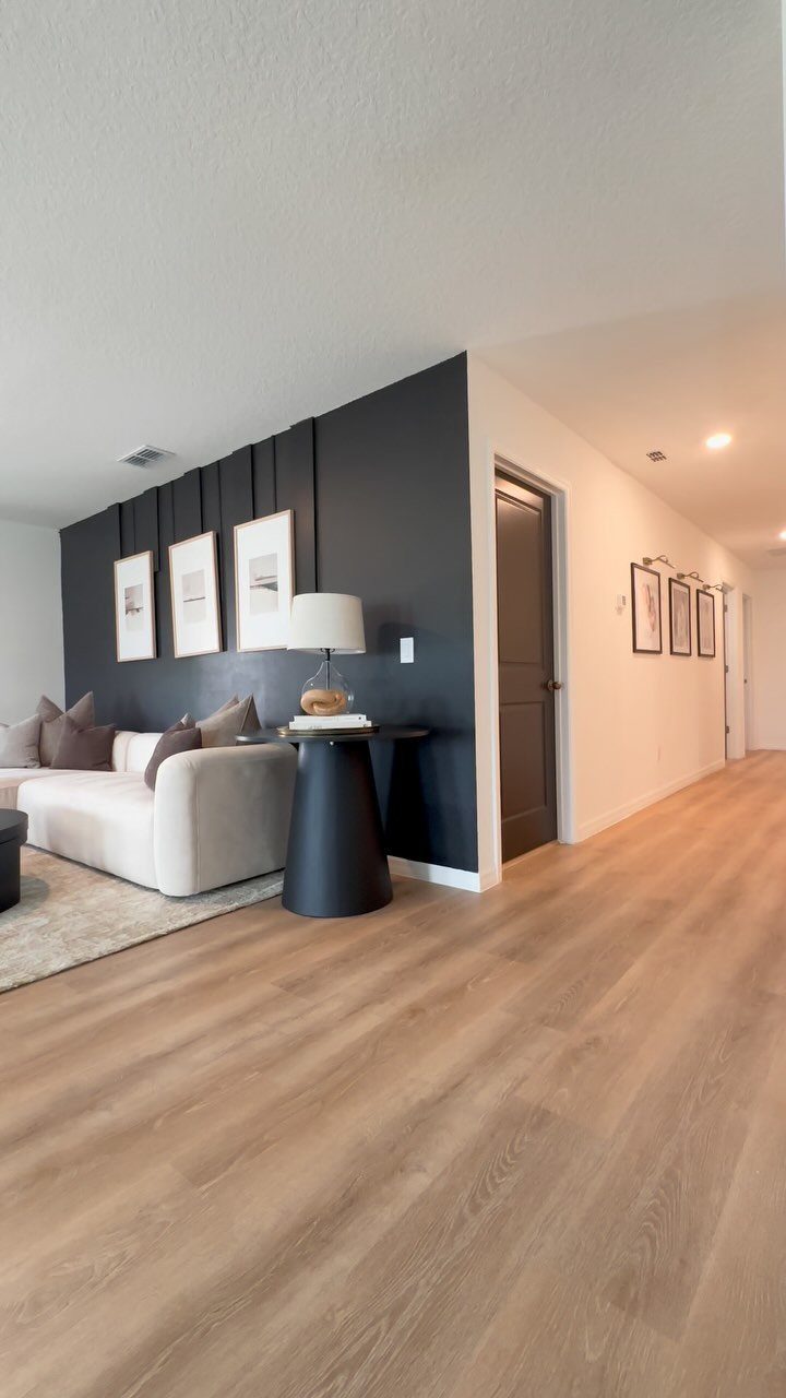 Light brown wood-look plank flooring extending through a modern living room and hallway.