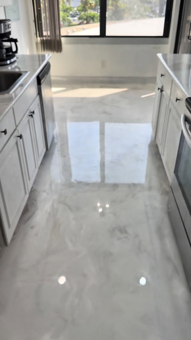 Marble-patterned white vinyl flooring in a bright, modern kitchen with white cabinets.