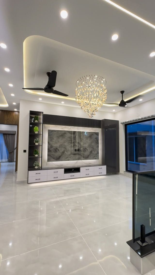 Modern living room with a large marble-patterned TV unit and crystal chandelier.
