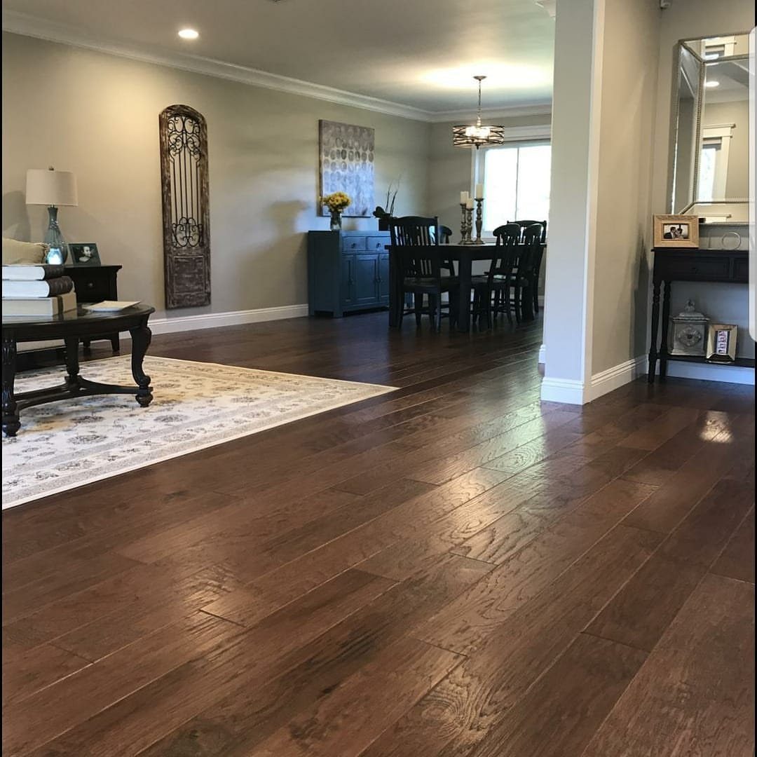 Dark chocolate brown wood plank flooring in a living and dining room area.