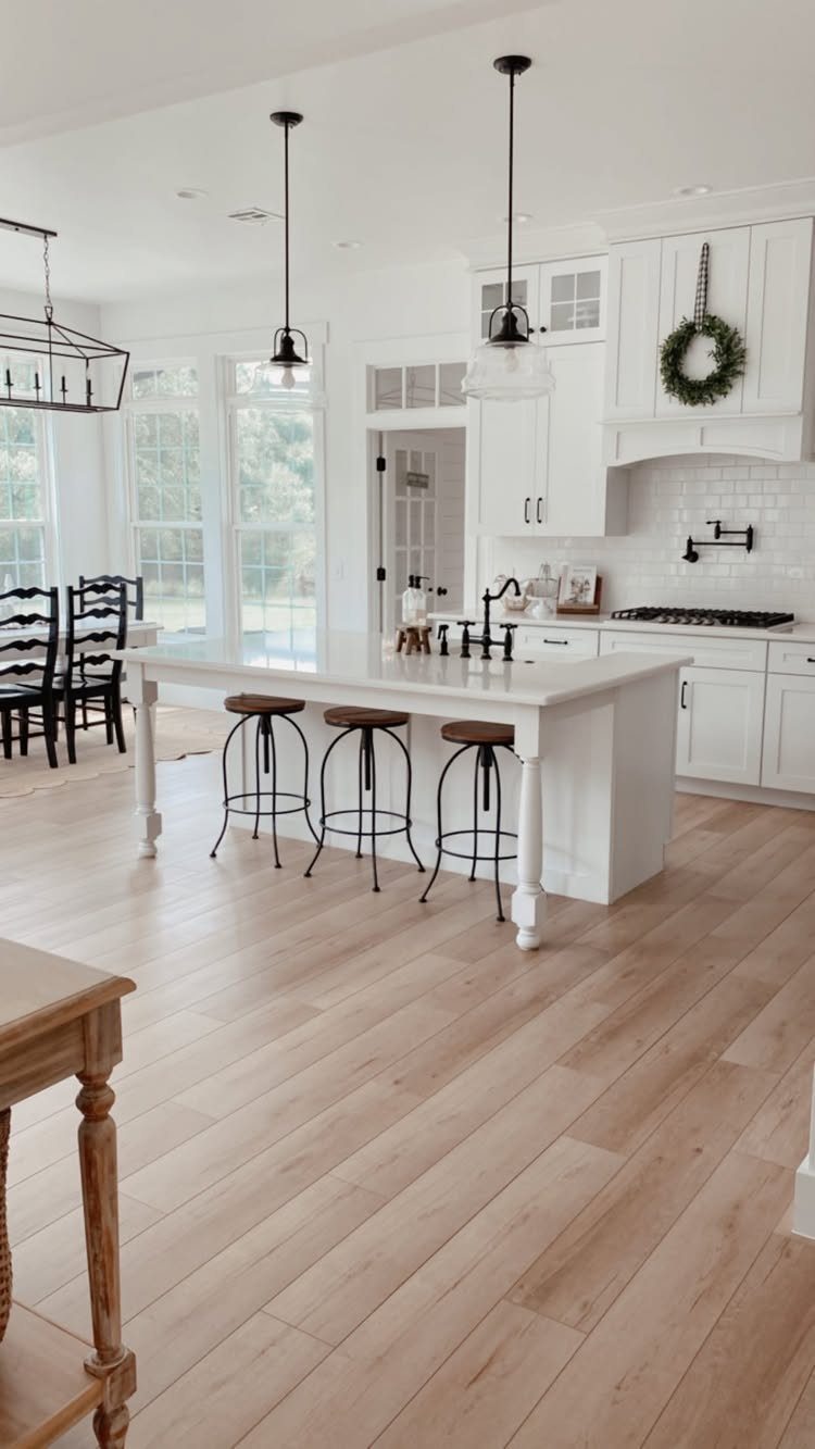 Light white oak wood flooring in a bright, modern kitchen with a white island.