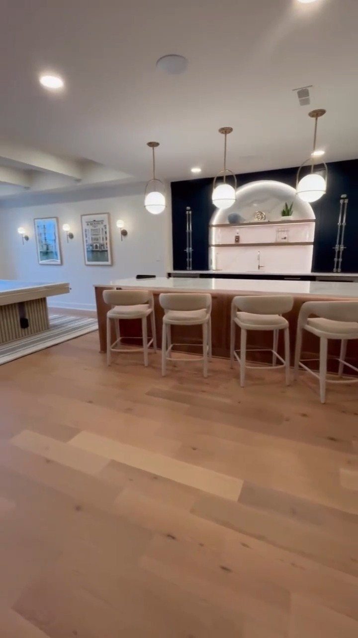 Light blonde wide plank wood flooring in a modern, bright kitchen interior.